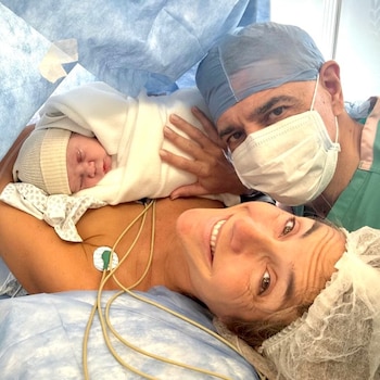 María Belén Ludueña sonriendo en camilla con su bebé Vito, envuelto en blanco. Jorge Macri, con barbijo y gorro quirúrgico, mira a cámara