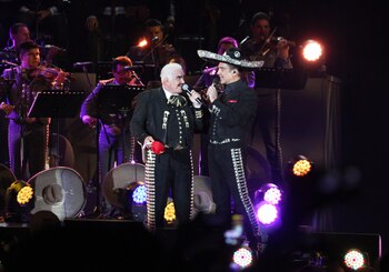 ARCHIVO - Vicente Fernández canta con su hijo Alejandro durante un concierto gratuito en el Estadio Azteca de la Ciudad de México el 16 de abril 2016. El astro de la música regional mexicana, Vicente Fernández, falleció el 12 de diciembre de 2021, informaron sus familiares. (AP Photo/Marco Ugarte, archivo)