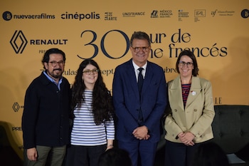 Cuatro personas posan frente a un fondo amarillo con logotipos institucionales y la inscripción Tour de Cine Francés