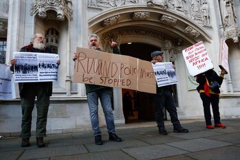 Manifestantes sostienen pancartas frente al