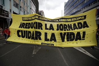 AME8396. SAN JOSÉ (COSTA RICA), 01/05/2026.- Personas sostienen un cartel en una manifestación durante la conmemoración del Día Internacional del Trabajo este viernes, en San José (Costa Rica). EFE/ Jeffrey Arguedas