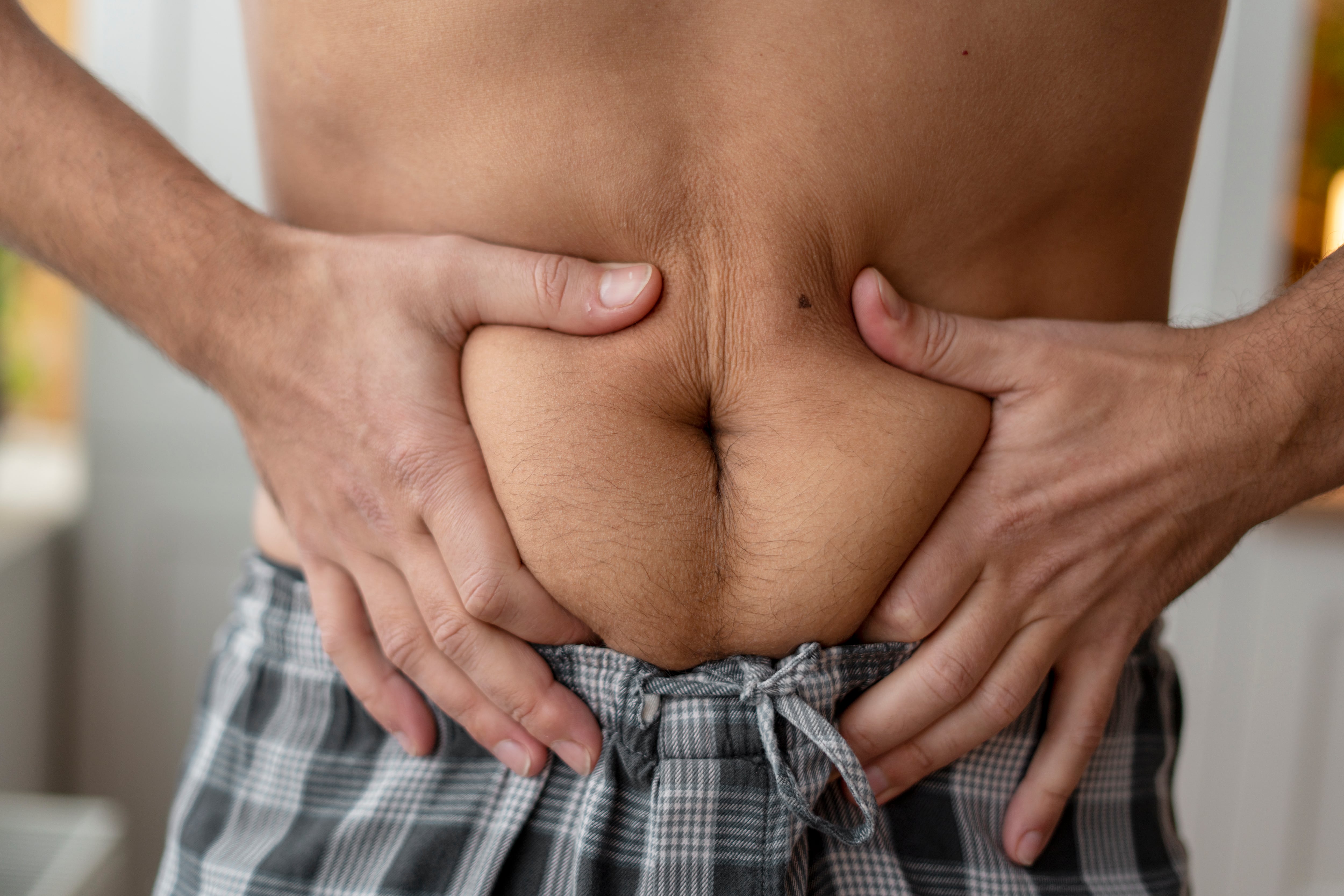 Un hombre presiona sus manos sobre el abdomen (Magnific)