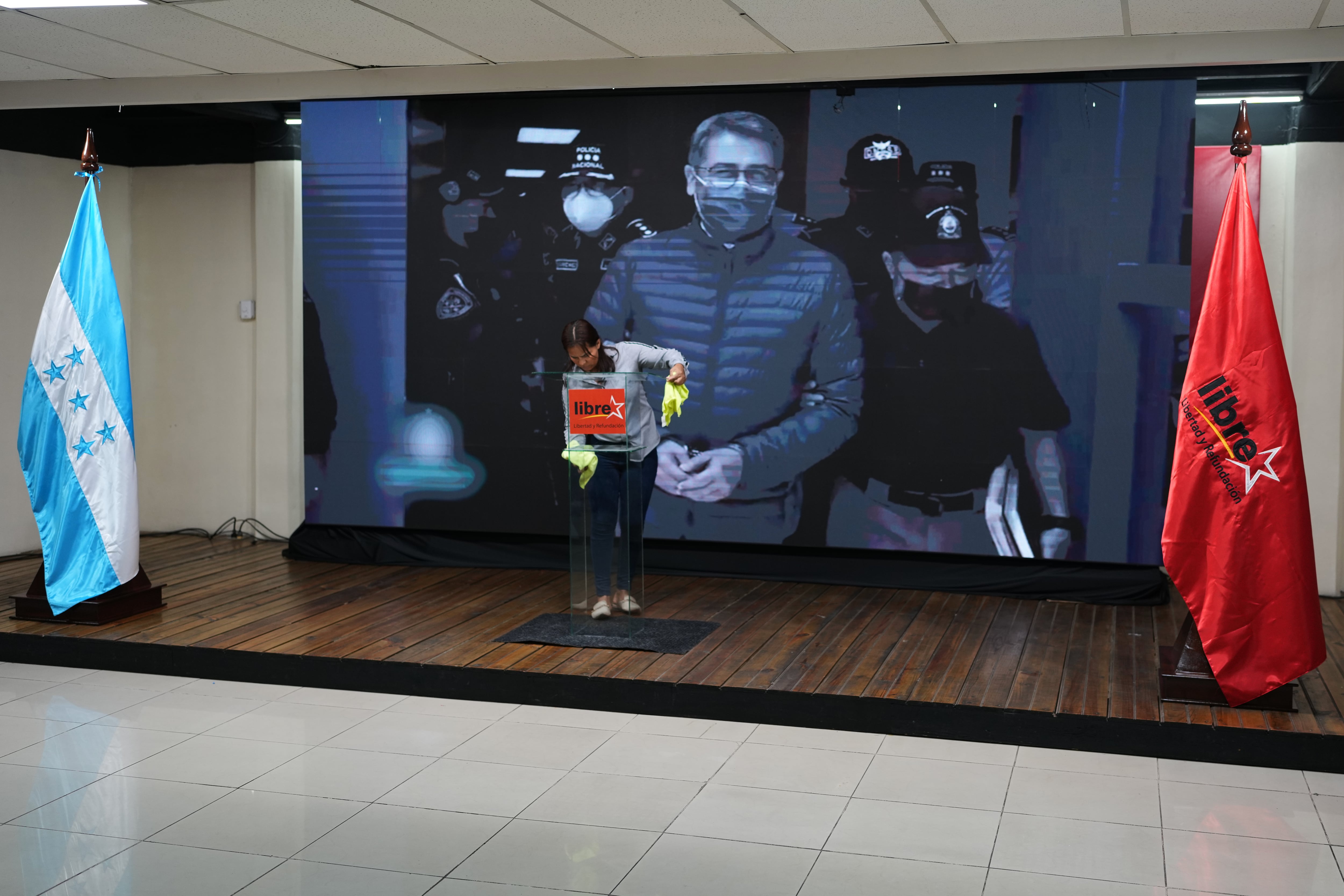 Una pantalla muestra la imagen del expresidente hondureño Juan Orlando Hernández, un día después de que el mandatario estadounidense Donald Trump dijera que planea indultarlo de una sentencia de narcotráfico emitida en 2024, antes del inicio de una conferencia de prensa de la candidata del partido en el poder, Rixi Moncada, en Tegucigalpa, Honduras, el sábado 29 de noviembre de 2025 (AP Foto/Moises Castillo)