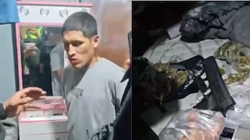 Un hombre con camiseta gris junto a un espejo y un arma de fuego colocada sobre un colchón junto a bolsas con vegetación seca