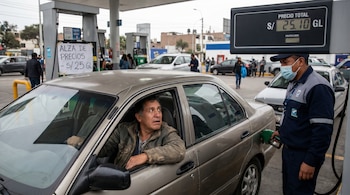 Un despachador con mascarilla llena el tanque de un coche color champán, mientras el conductor, con expresión de preocupación, mira el indicador de precio de gasolina de S/ 25.10.