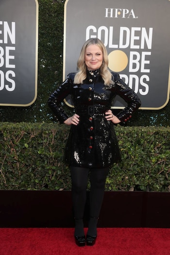 Amy Poehler, una de las presentadoras de la noche, lució un traje de paillettes negro de mangas largas abotonado con medias traslúcidas y zapatos de taco cuadrado cerrados