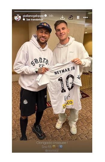 Dos futbolistas, Neymar Jr. y Ander Herrera, sonríen mientras sostienen una camiseta blanca con el nombre 'NEYMAR JR' y el número 10 en un interior