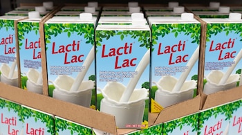 Envases de cartón de bebida láctea con grasa vegetal de la marca Lacti Lac colocados en cajas de exhibición.
