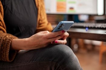 Una mujer silencia las notificaciones de su teléfono móvil (Magnific)