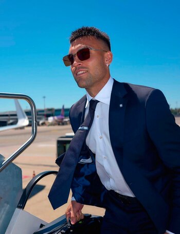 Para traslados aéreos, elige traje azul marino, camisa blanca y corbata al tono, sumando gafas de sol rectangulares y pendientes plateados