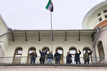 Un grupo de hombres izó la emblemática bandera de la oposición con tres estrellas rojas, cuando caían sobre Moscú algunos copos de nieve. (Andrey BORODULIN / AFP)