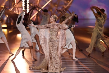 El impactante vestido de lentejuelas doradas y capa translúcida que Céline Dion lució en el desfile “The 1001 Season of Elie Saab” encarna su preferencia por el brillo y la transparencia en escena (REUTERS/Hamad I Mohammed/File Photo)