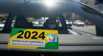 Primer plano de un marbete amarillo y verde con el año 2024, el escudo de Guatemala y la inscripción "Impuesto de Circulación de Vehículos".