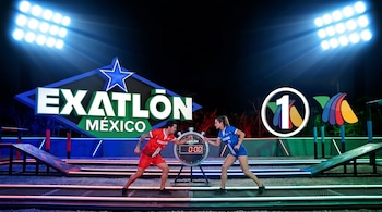 Dos atletas, un hombre y una mujer, de pie en un circuito deportivo iluminado de noche, con el logo de Exatlón México y Azteca Uno de fondo y un cronómetro en "0:00".