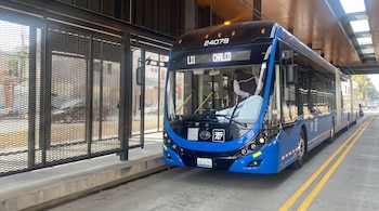 Autobús azul y negro número 24079 con el letrero L11 Chalco detenido junto a una plataforma con rejilla metálica y líneas amarillas.