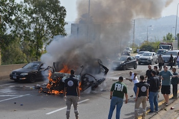 Fuerzas de seguridad y personal de emergencia se congregan alrededor de un vehículo en llamas debido a un ataque aéreo, el miércoles 13 de mayo de 2026 en Líbano (AP/Mustafa Jamalddine)