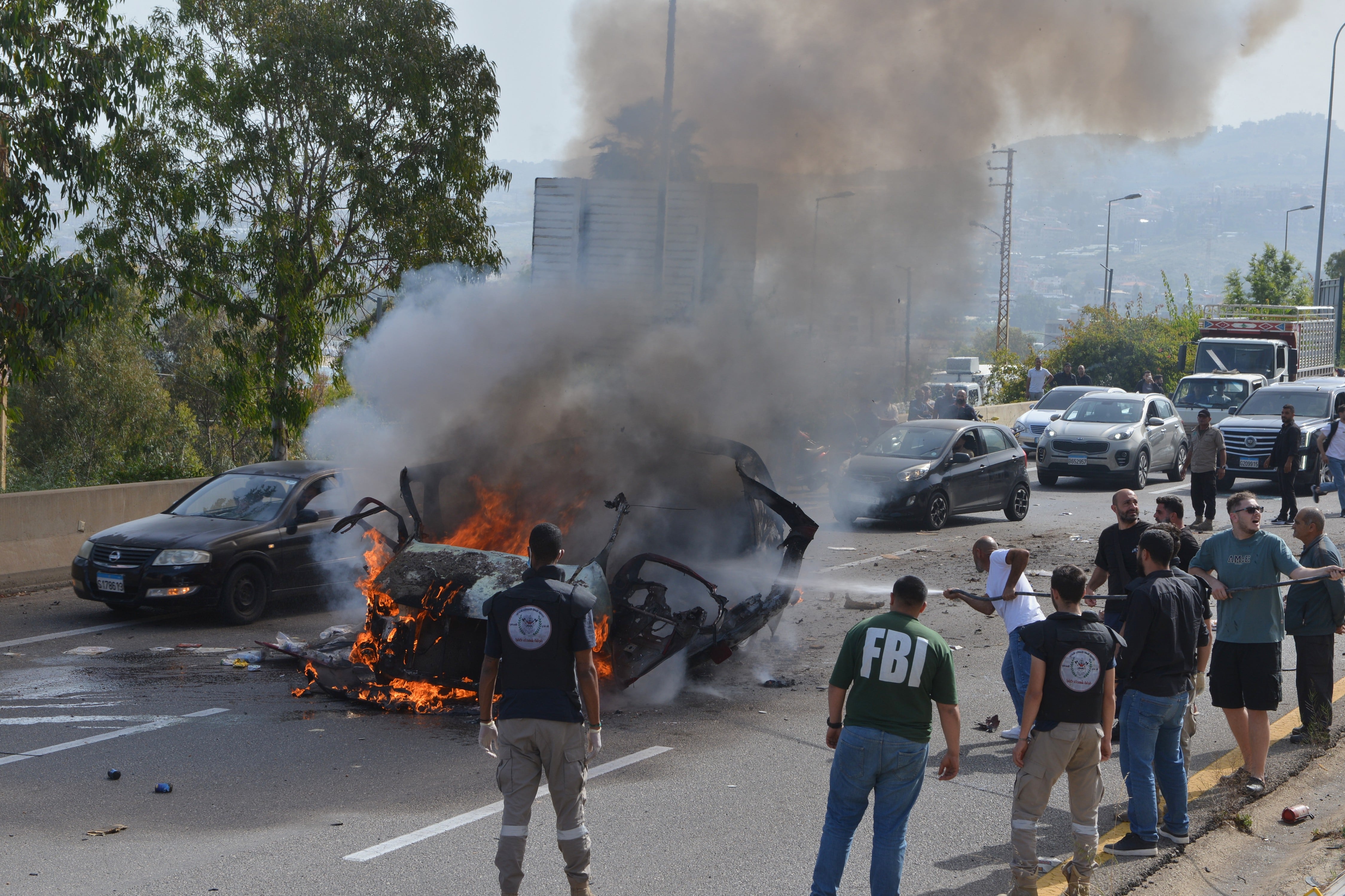 Fuerzas de seguridad y personal de emergencia se congregan alrededor de un vehículo en llamas debido a un ataque aéreo, el miércoles 13 de mayo de 2026 en Líbano (AP/Mustafa Jamalddine)