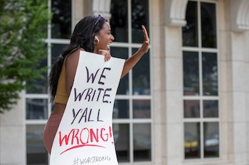 Actor and aspiring television and film writer Kim Steele holds a sign in support of the Writers Guild of America strike outside of the Warner Bros. Discovery Atlanta campus after the Writers Guild of America began their strike against the Alliance of Motion Pictures and Television Producers, in Atlanta, Georgia, U.S. May 2, 2023. REUTERS/Alyssa Pointer