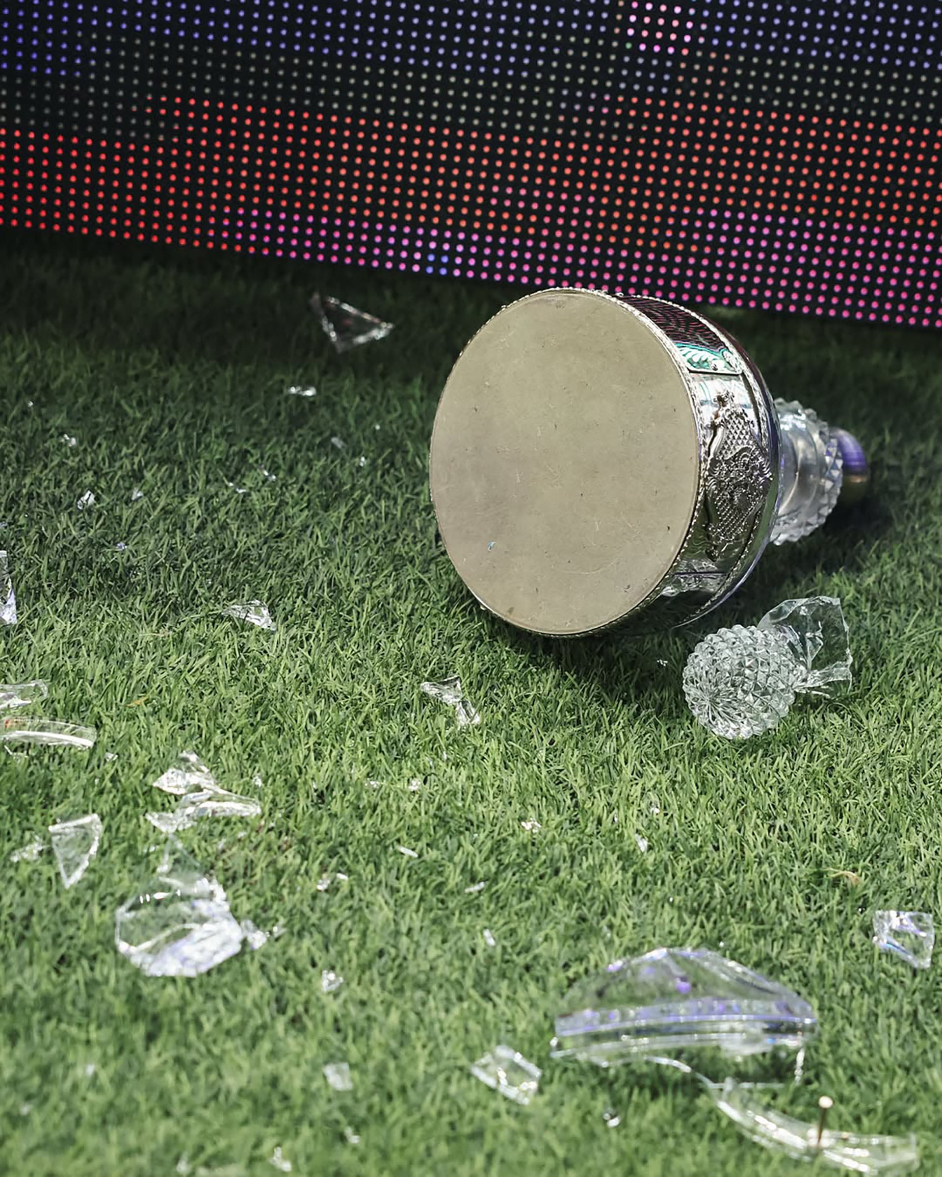 El trofeo roto se ve en el césped, con sus pedazos de cristal esparcidos, después de que Pablo Solari lo rompiera durante la celebración.