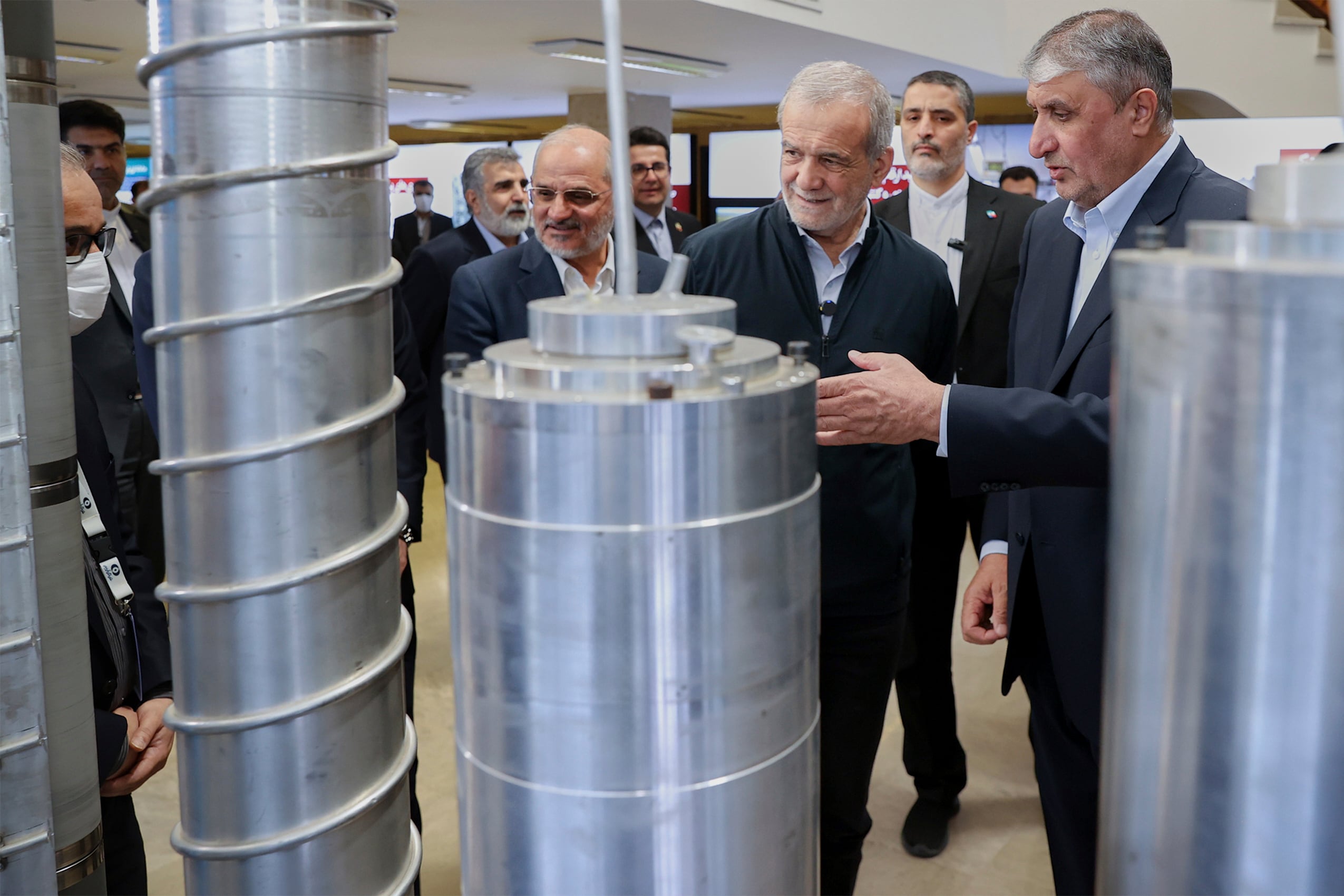 En esta fotografía difundida por la presidencia de Irán, el presidente iraní Masoud Pezeshkian, segundo de derecha a izquierda, escucha la explicación del jefe de la Organización de Energía Atómica de Irán, Mohammad Eslami, durante su visita a una exhibición de logros nucleares del país, en Teherán, Irán, el miércoles 9 de abril de 2025. (Presidencia de Irán vía AP)