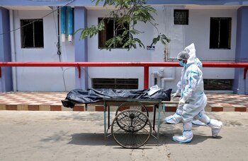 Trabajadores de la salud llevan el cuerpo de una persona que murió por la enfermedad del coronavirus (COVID-19), dentro de las instalaciones de un hospital en Calcuta, India, el 12 de mayo de 2021. REUTERS / Rupak De Chowdhuri
