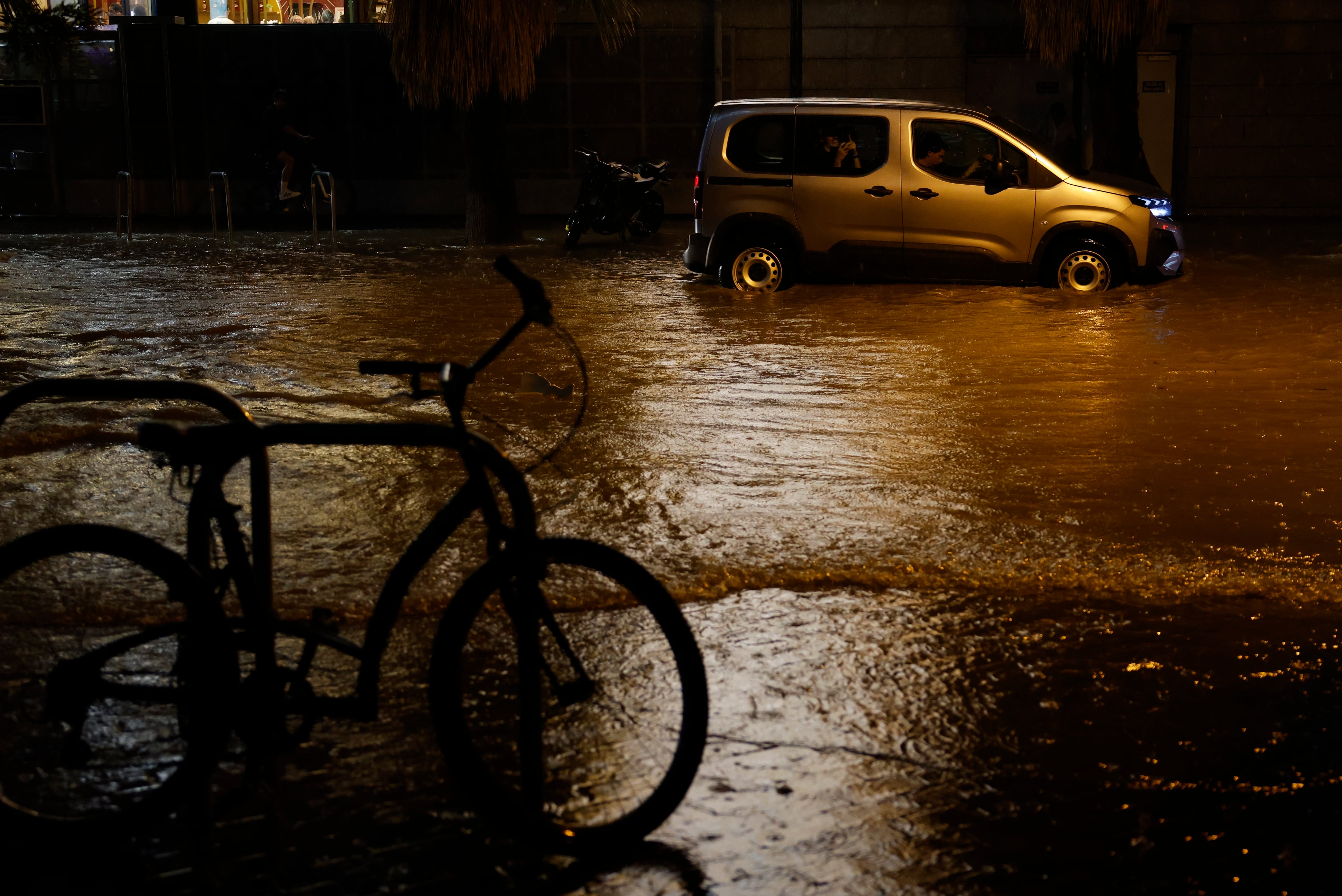 Coches circulan por una calle inundada tras las fuertes lluvias caídas en Valencia, el miércoles. (EFE/ Ana Escobar)