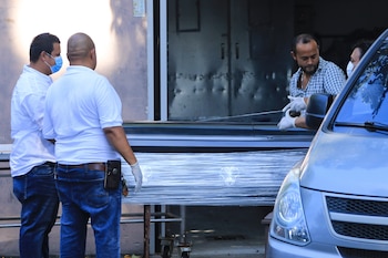 Personas cargan hoy, un ataúd con uno de los cuerpos de las tres mujeres asesinadas, en San Pedro Sula (Honduras). EFE/José Valle
