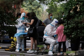 Trabajadores sanitarios registran los datos de varias personas en un punto de pruebas de COVID-19 en Pekín, China, el 6 de julio de 2022. REUTERS/Thomas Peter