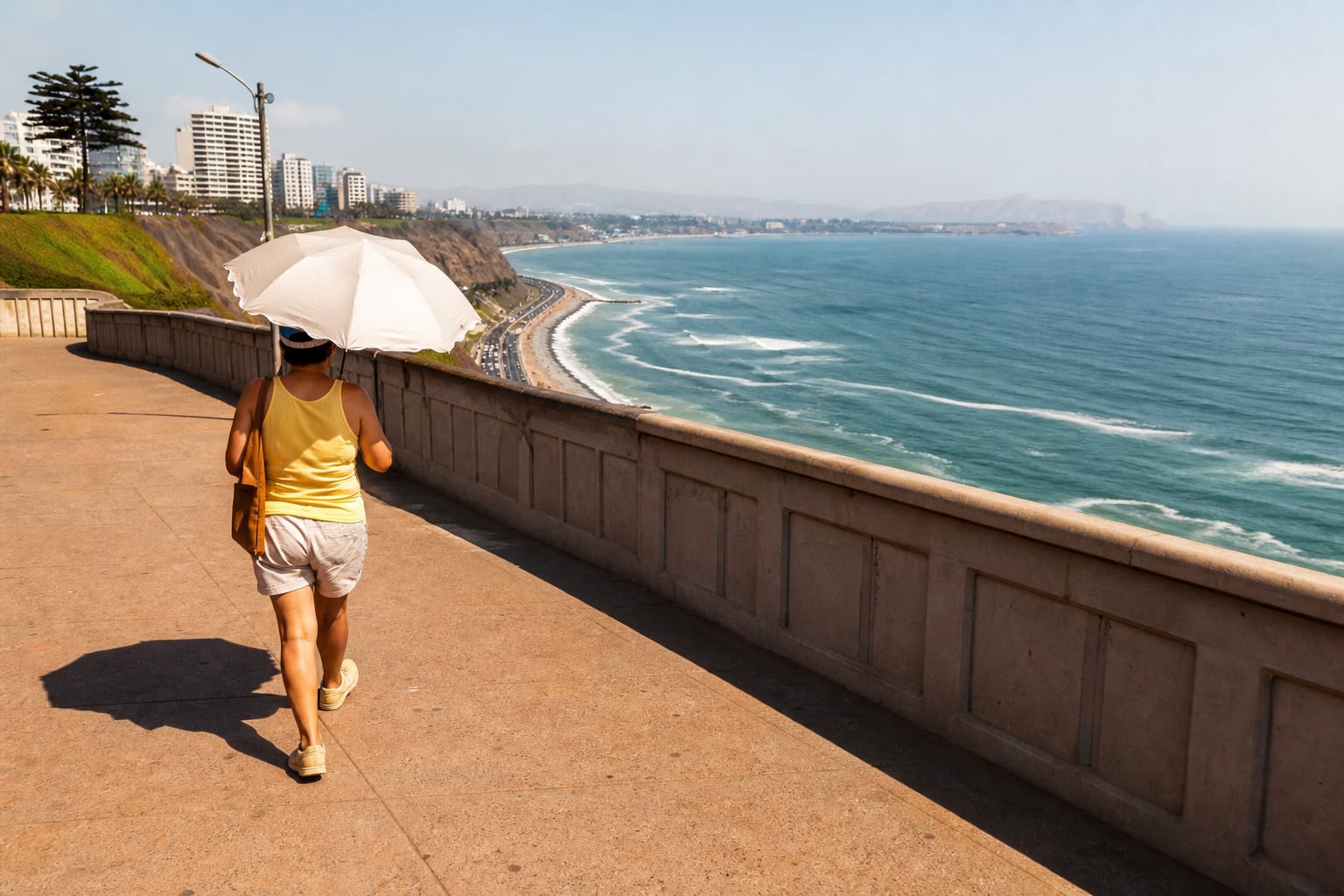 Una transeúnte se protege con una sombrilla de la radiación solar mientras recorre el malecón de Lima. (Imagen Ilustrativa Infobae)