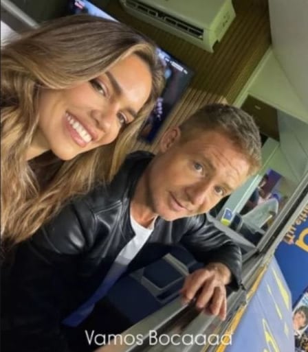 Rocío Robles y Adrián Suar posan sonrientes para una selfie en las gradas de La Bombonera, mostrando su apoyo al equipo.