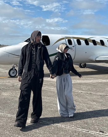 La Joaqui y Tiago PZK, tomados de la mano sobre la pista, antes de abordar un avión privado