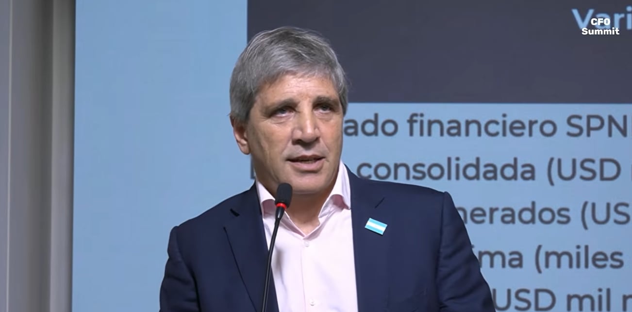 El ministro de Economía de Argentina, Luis Caputo, ofrece un discurso durante el encuentro empresarial CFO Summit frente a una pantalla con información financiera.