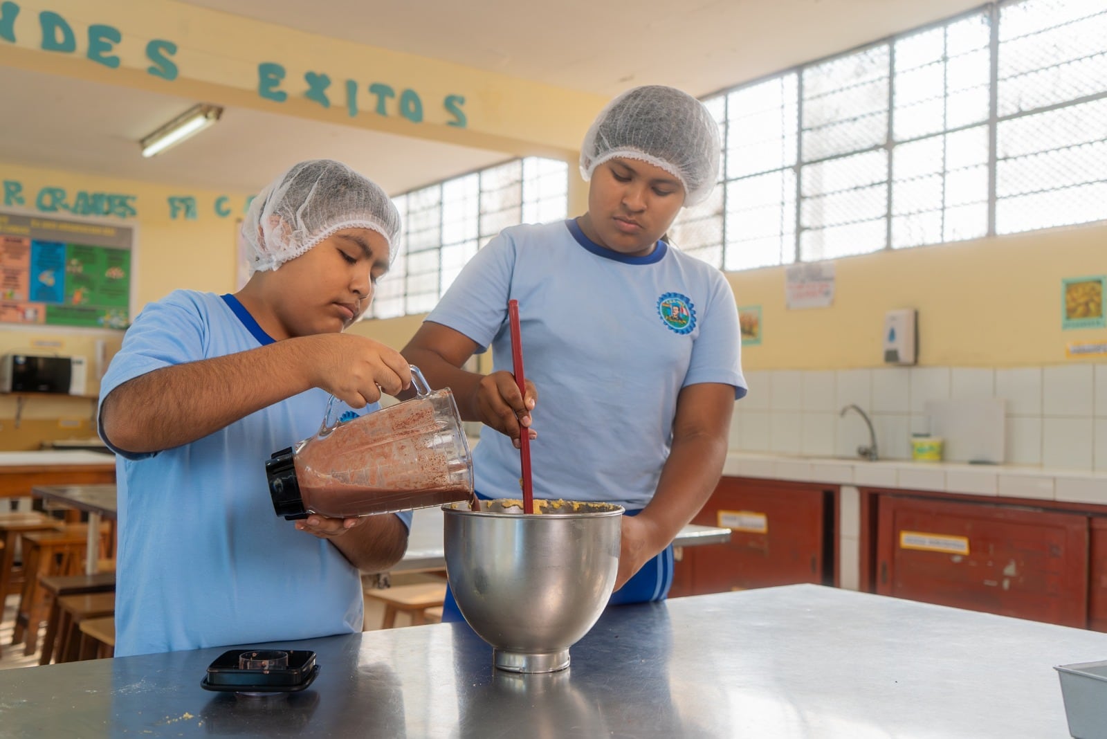 Dos escolares preparan alimentos en un taller práctico dentro de una iniciativa que promueve competencias emprendedoras en Perú.