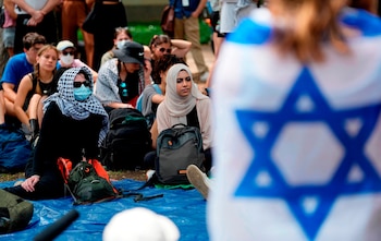 Una estudiante arropada con una bandera israelí escucha a manifestantes propalestinos en la Universidad de Texas en Austin (AP foto/Eric Gay/Archivo)