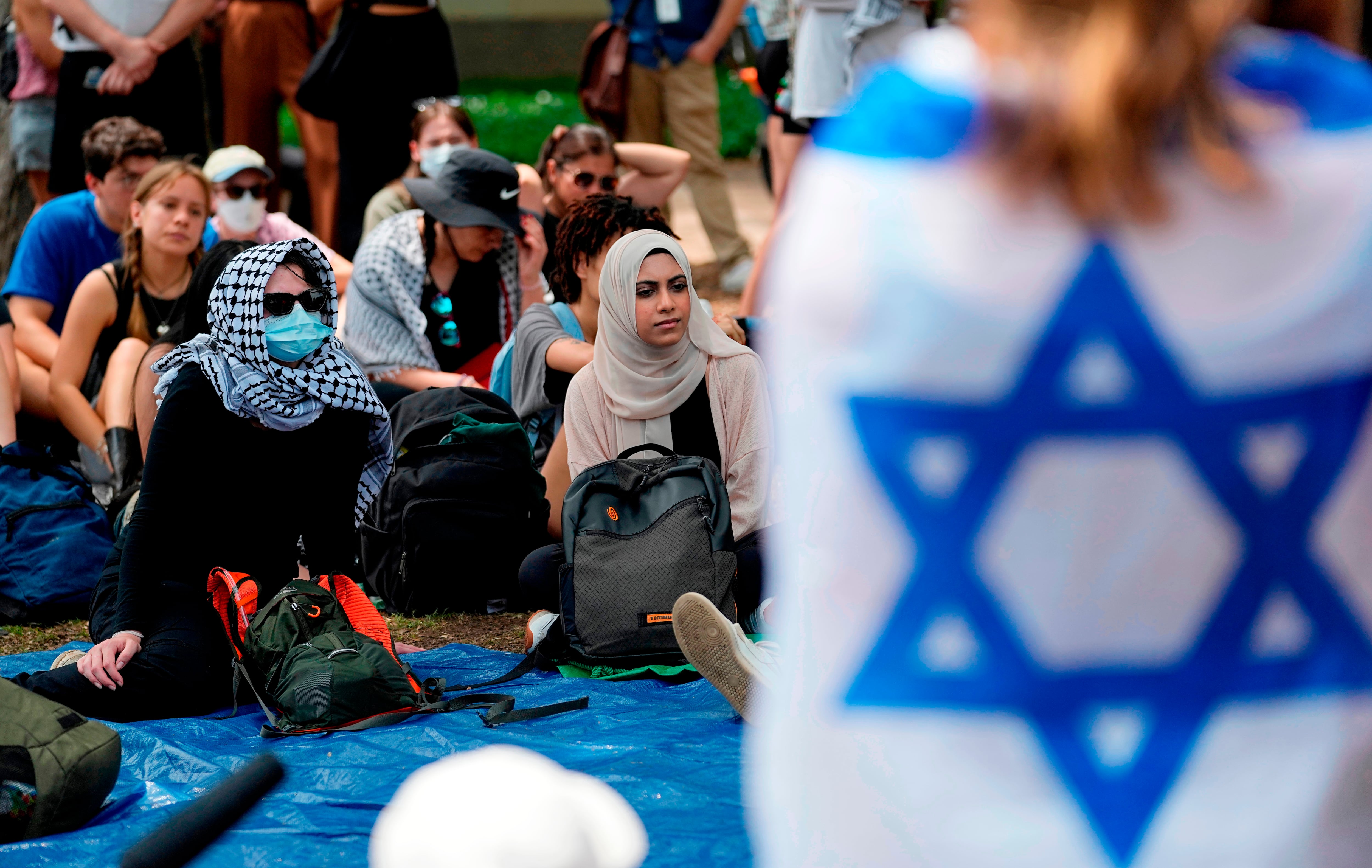Una estudiante arropada con una bandera israelí escucha a manifestantes propalestinos en la Universidad de Texas en Austin (AP foto/Eric Gay/Archivo)