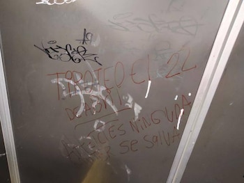 Graffiti en una superficie gris que dice "TIROTEO EL 22 DE ABRIL" y "NI NINGUNA SE SALVA" en marcador rojo, junto con otros garabatos negros