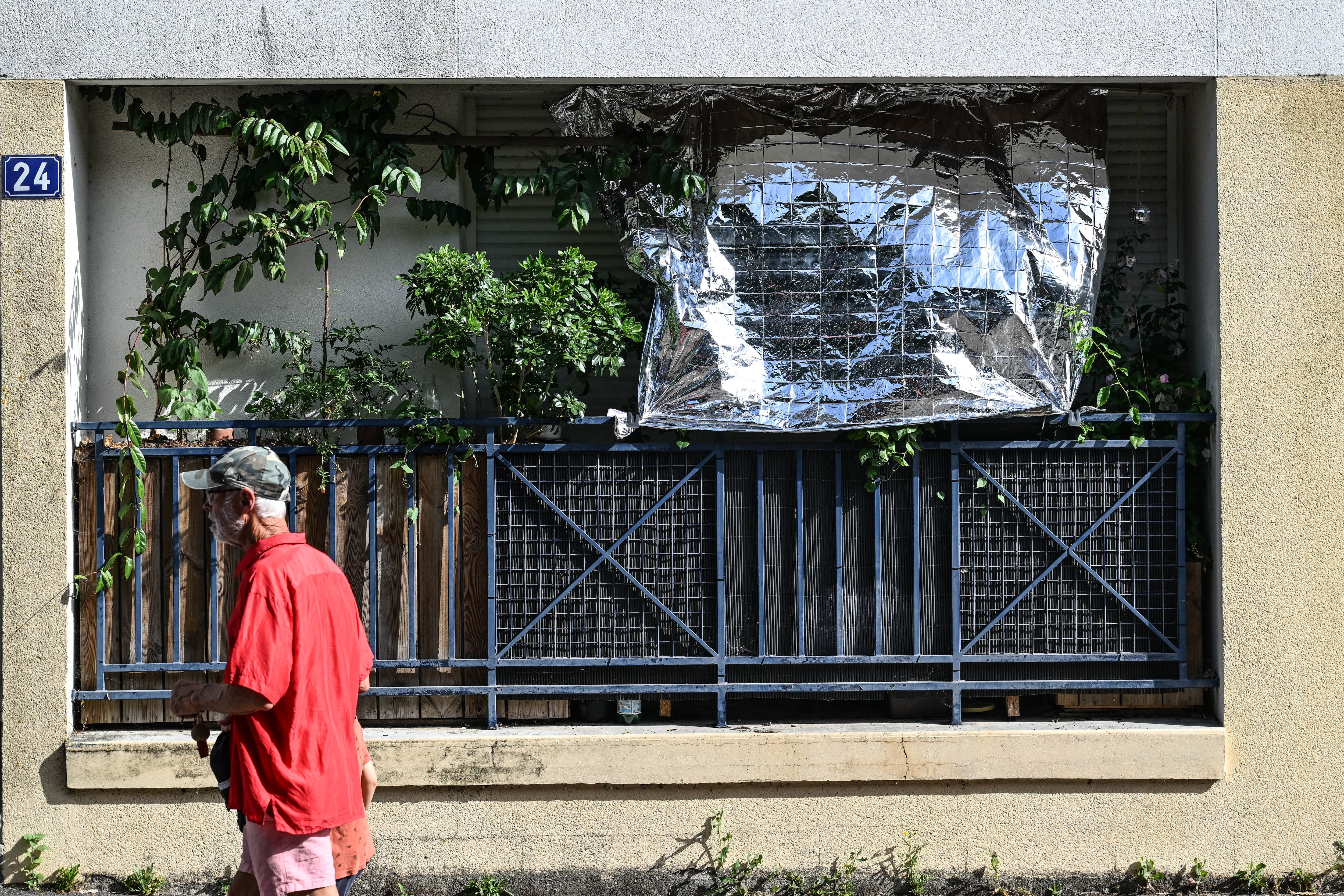 Un hombre camina frente a una ventana cubierta con una manta térmica en Nantes, oeste de Francia, el 23 de junio de 2026, durante la ola de calor que golpea a Europa. (Foto Sebastien Salom-Gomis/AFP)