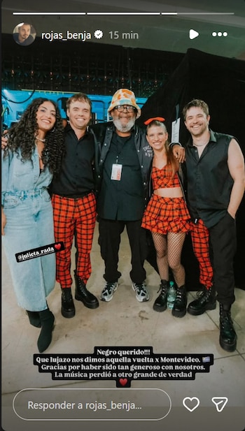 Cinco personas posan sonrientes entre bastidores, tres de ellas con ropa con estampado a cuadros rojos y negros