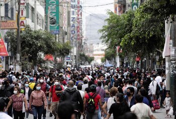FOTO DE ARCHIVO. La gente camina en una calle llena de gente mientras los nuevos casos de la enfermedad del coronavirus (COVID-19), impulsada por la variante Omicron, están aumentando, en Lima, Perú el 12 de enero de 2022. Foto tomada el 12 de enero de 2022. REUTERS/Angela Ponce
