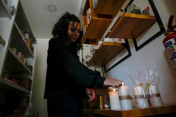 Una mujer enciende velas en
