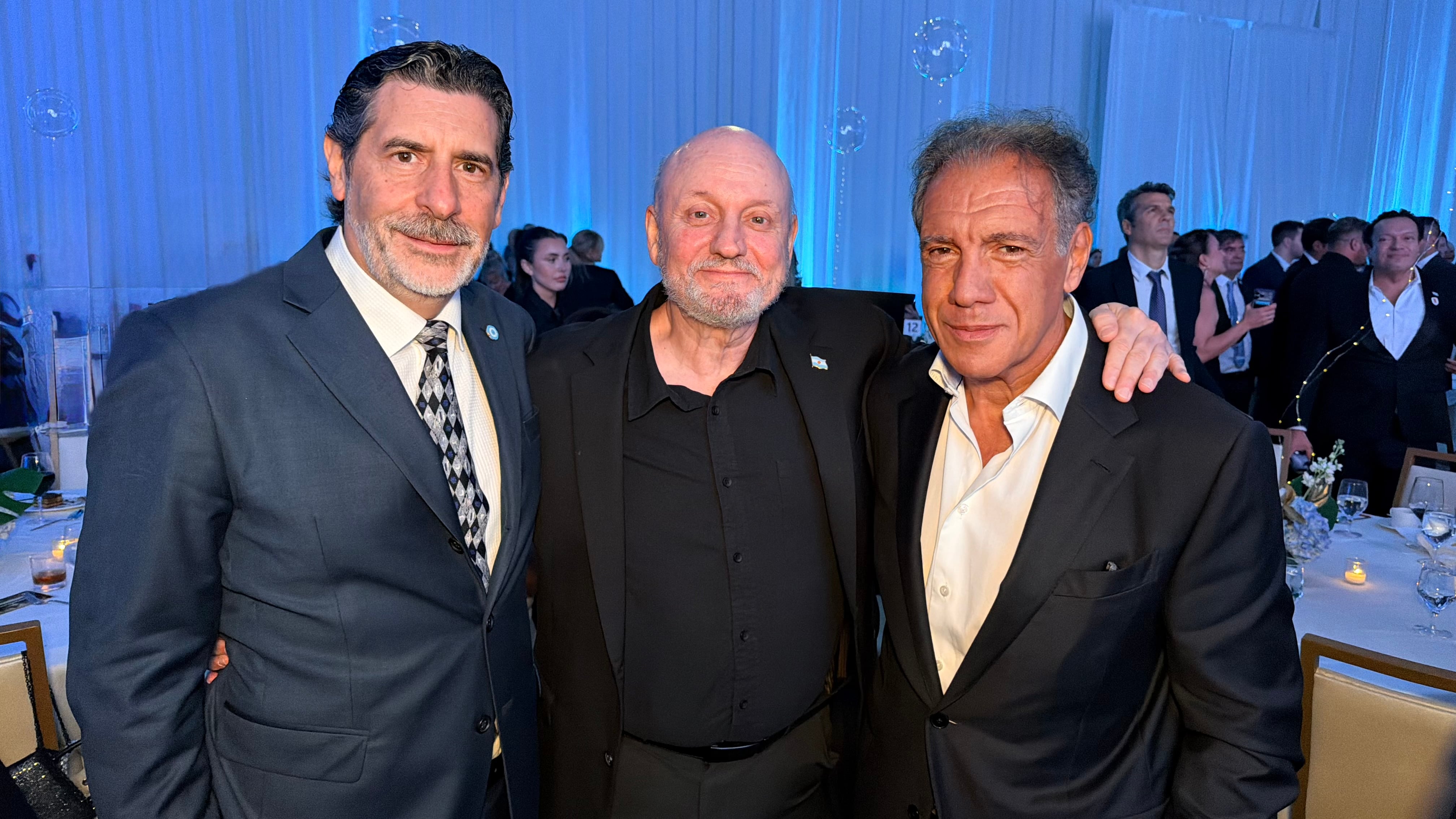 Roberto Macho, Juan José Campanella y Daniel Hadad posan juntos durante la gala anual de la Cámara Argentino-Americana de Comercio celebrada en Miami.
