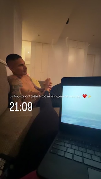Paolo Guerrero sentado en un sofá realiza un masaje de pies a una persona que sostiene una computadora portátil
