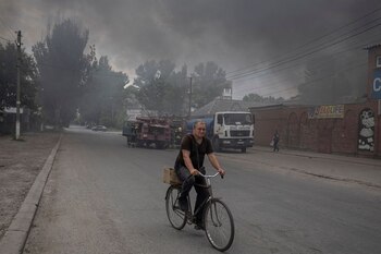 Un hombre monta una bicicleta por una calle en el mercado después de los bombardeos, mientras continúa el ataque de Rusia contra Ucrania, en Sloviansk, región de Donetsk, Ucrania, 5 de julio de 2022 (REUTERS/Marko Djurica)