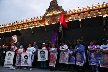Relatives hold banners with images