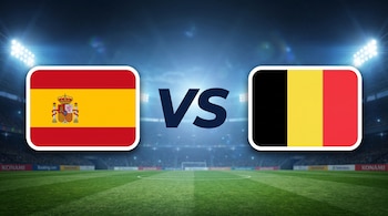 Bandera de España con escudo, bandera de Bélgica, texto VS, campo de fútbol, estadio con gradas y focos encendidos.