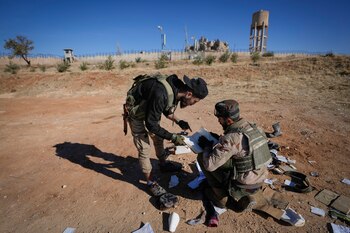Dos combatientes insurgentes examinan documentos