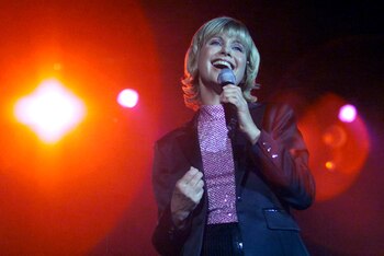 FILE PHOTO: Olivia Newton-John sings at her "Greatest Hits Live" concert in Hong Kong August 18, 2000. The 51-year-old singer will perform with Australian singer John Farnham at the opening ceremony of the Sydney 2000 Olympic Games in September. Reuters/Reuters Photographer/File Photo