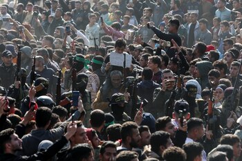 Militantes palestinos portan rifles el día que entregan rehenes.