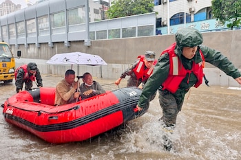 Residentes varados son evacuados en un bote durante una inundación tras fuertes lluvias en Qinzhou, en la Región Autónoma de Guangxi Zhuang, en el sur de China. (Ao Shuaichang/Xinhua via AP)