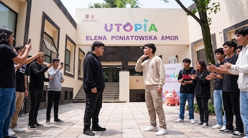 Dos jóvenes se enfrentan al centro de una plaza mientras otros adolescentes los rodean, graban con sus teléfonos móviles y aplauden.